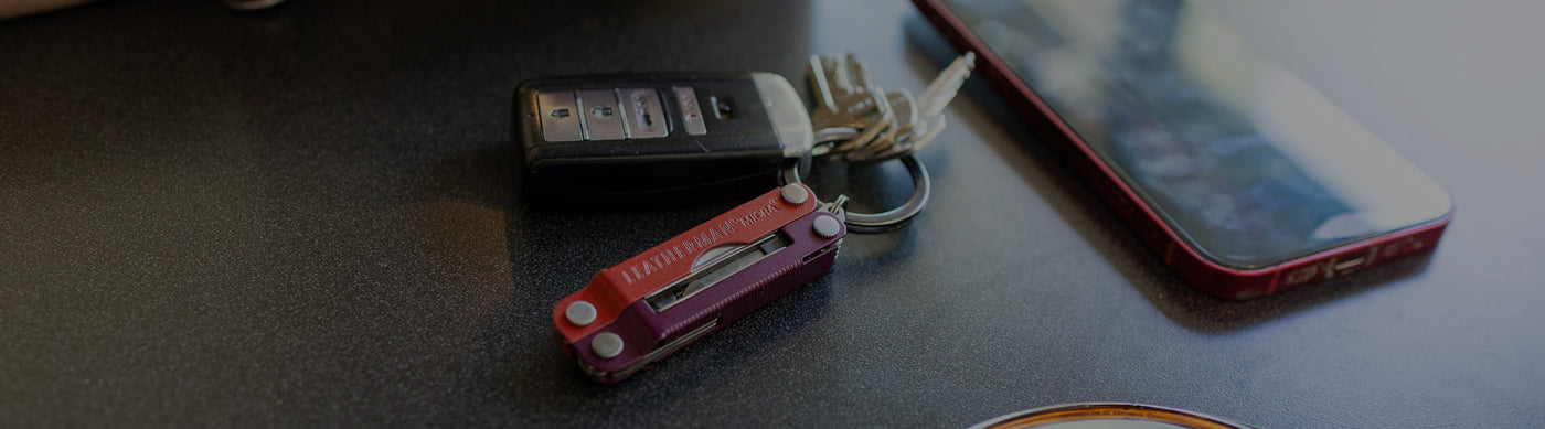 Translation missing: en.Leatherman Micra with keys, car key fob, and smartphone on a dark surface