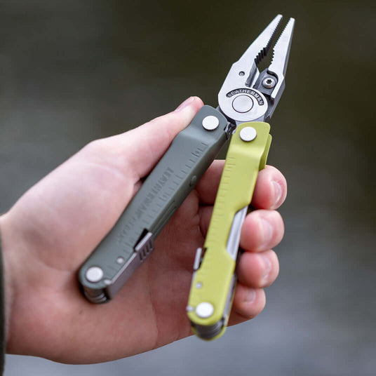 Person holding a Mossy Slate Leatherman Rebar multi-tool, perfect for outdoor activities and repairs.