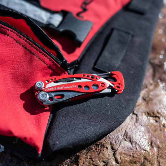 Close-up of a red Leatherman Skeletool® RX on a black and red bag, showcasing its versatility and design.