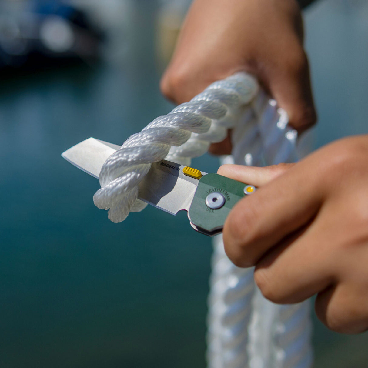 Translation missing: en.A person using Leatherman Glider to cut through a thick rope