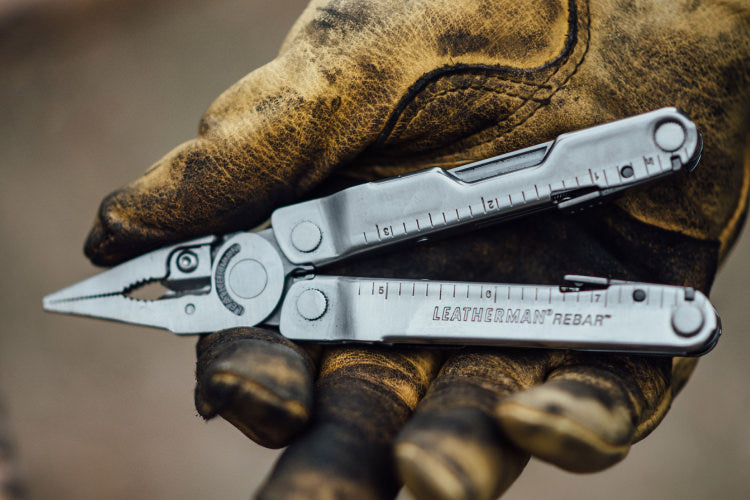 Translation missing: en.Gloved hand holding a leatherman Rebar with the pliers out