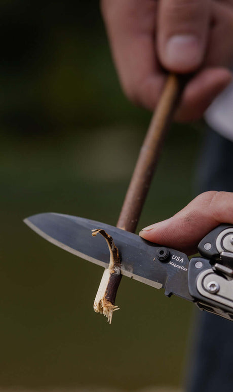 Translation missing: en.Leatherman ARC with Magnacut blade deployed sharpening a small stick