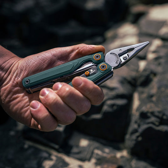 Translation missing: en.Hand holding a Wave Alpha multi-tool with a Cascadia color design, showcasing its sleek and practical features