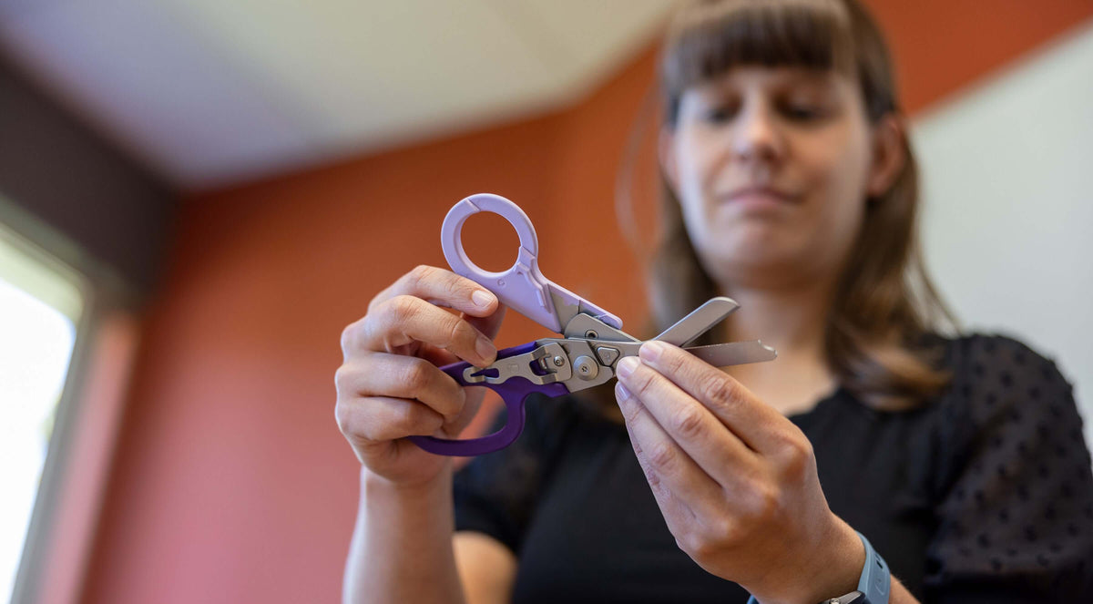 Melissa Lee holding the Orchid Leatherman Raptor® Rescue demonstrating it's versatility.