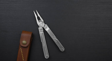 Stainless steel Leatherman PST® pliers on a dark background with a Leatherman brown Heritage sheath.