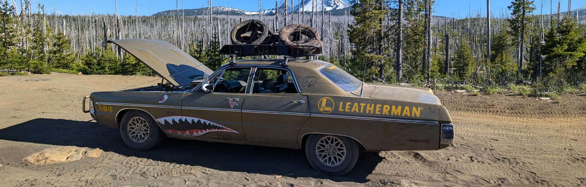 Car with Leatherman name and logo on it parked in nature with a raised hood, showcasing adventure and off-road spirit.