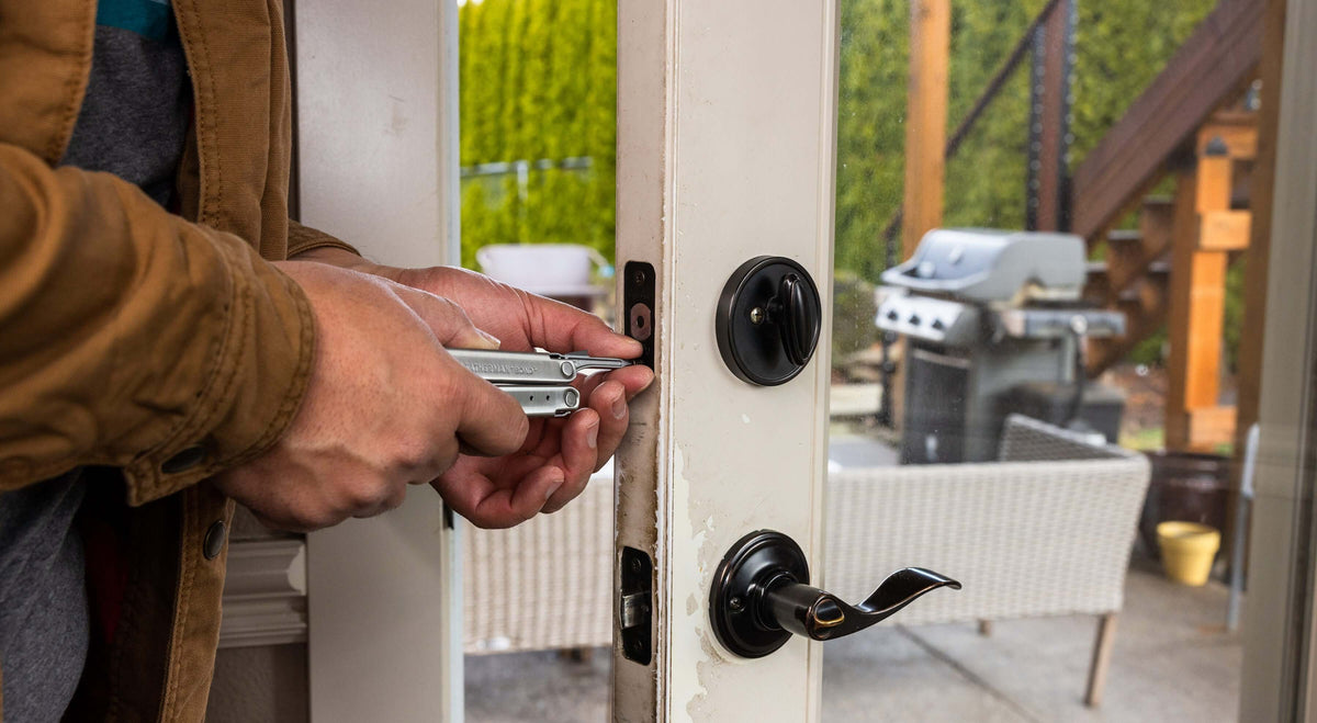 Person using stainless steel Leatherman Bond® to work on door lock for home projects.