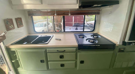Translation missing: en.Modern camper kitchen with double sink, gas stove, and ample storage, featuring a bright and spacious layout with a Stainless Steel Leatherman Skeletool® on top