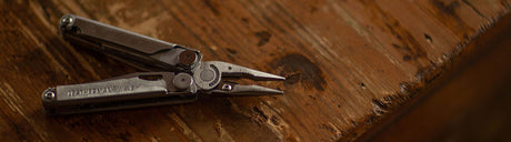 Translation missing: en.Leatherman Wave open in pliers position on wooder table