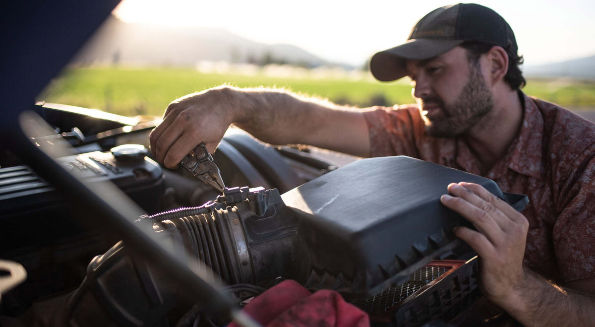 Man using a Stainless Steel Leatherman Surge® while working on an air intake.