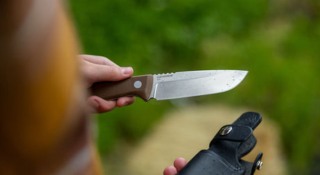 Translation missing: en.A hand holding the Leatherman TRAC fixed blade knife and sheath