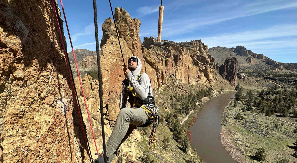 Rock climber at Smith Rock State Park with scenic cliffs and river backdrop in Central Oregon.