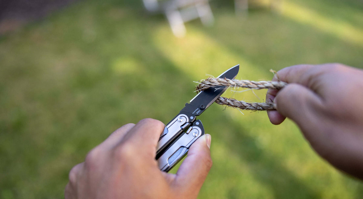 Person cutting rope with a stainless steel Leatherman ARC® MagnaCut® blade.