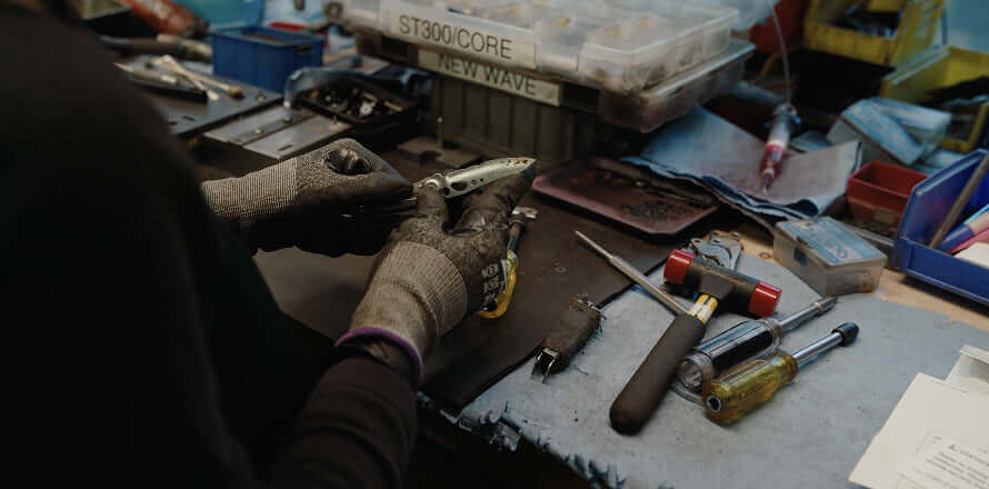 A person from Leatherman's Warranty department fixing a Stainless Steel Leatherman Skeletool® in a workshop.