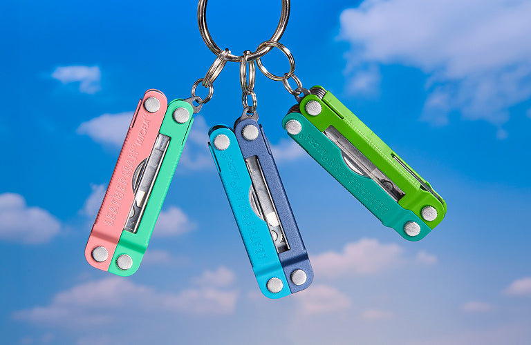 Translation missing: en.Four Leatherman Skeletool® CX multitools in various colors on a rocky surface