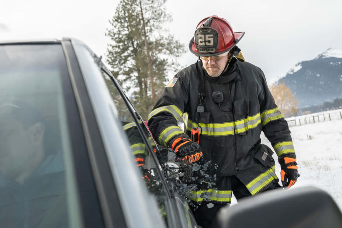 Translation missing: en.Firefighter using Raptor Rescue glass breaker to break a car window