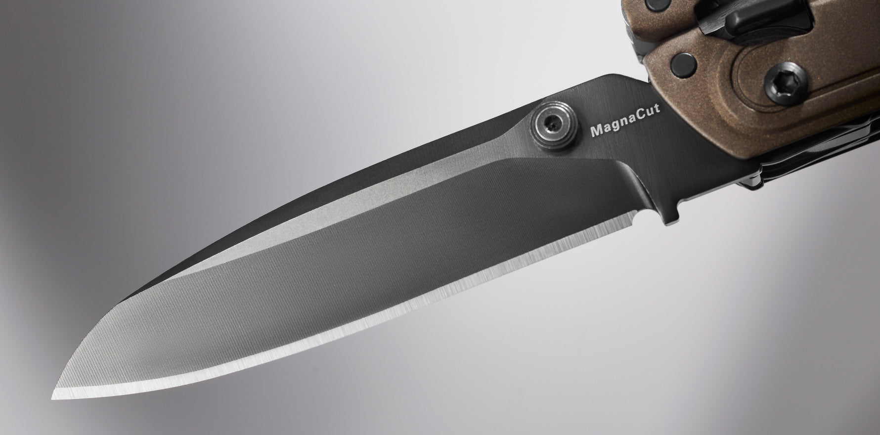 Close-up of a knife blade in MagnaCut steel, demonstrating sharpness and precision, ideal for outdoor enthusiasts.