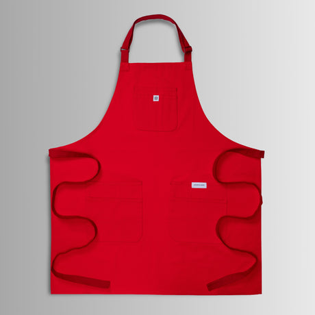 Translation missing: en.Red apron with neck strap, three front pockets, and long waist ties spread out flat