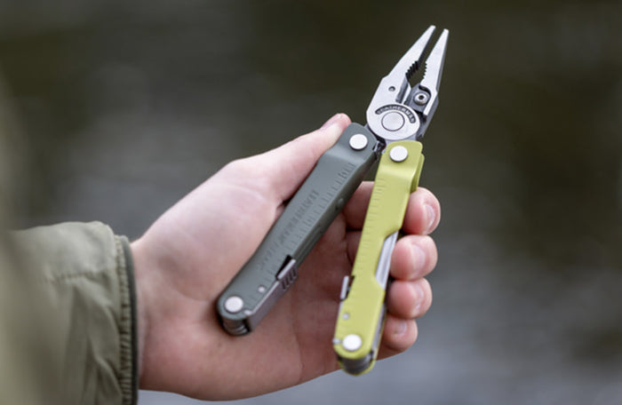 Translation missing: en.A hand holding a Mossy Slate Leatherman Rebar open with pliers showing, indicating readiness