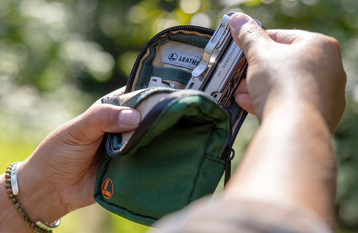 Translation missing: en.A person holding a Hunter green Leatherman Tool Pouch containing a Leatherman Arc, showcasing the inside of the pouch