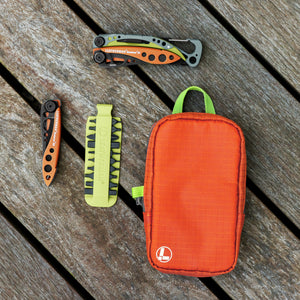 Translation missing: en.Leatherman Tool Pouch in Aurora color on a wooden surface next to a mojito colored bit kit, Aurora colored Leatherman Skeletool® KB and Skeletool® CX