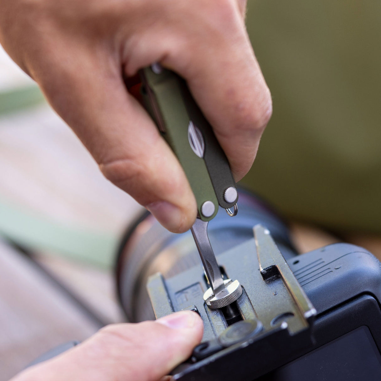 Translation missing: en.A person using the medium screwdriver on a Spruce Leatherman Micra® to tighten a camera mount