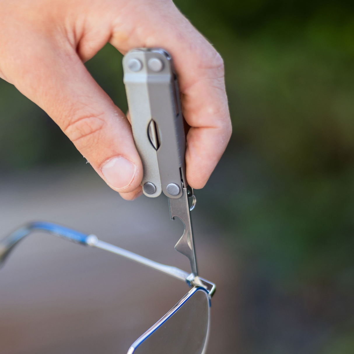 Translation missing: en.Person using the medium screwdriver on a Winter Fog Leatherman Micra® to tighten the hinge on a pair of eyeglasses