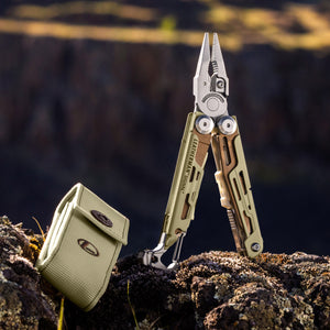 Translation missing: en.Sandstorm Signal multitool with open pliers and matching sheath resting on rocky terrain outdoors
