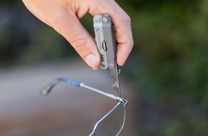 Translation missing: en.Person using a Winter Fog Leatherman Micra® tool to adjust eyeglasses outdoors