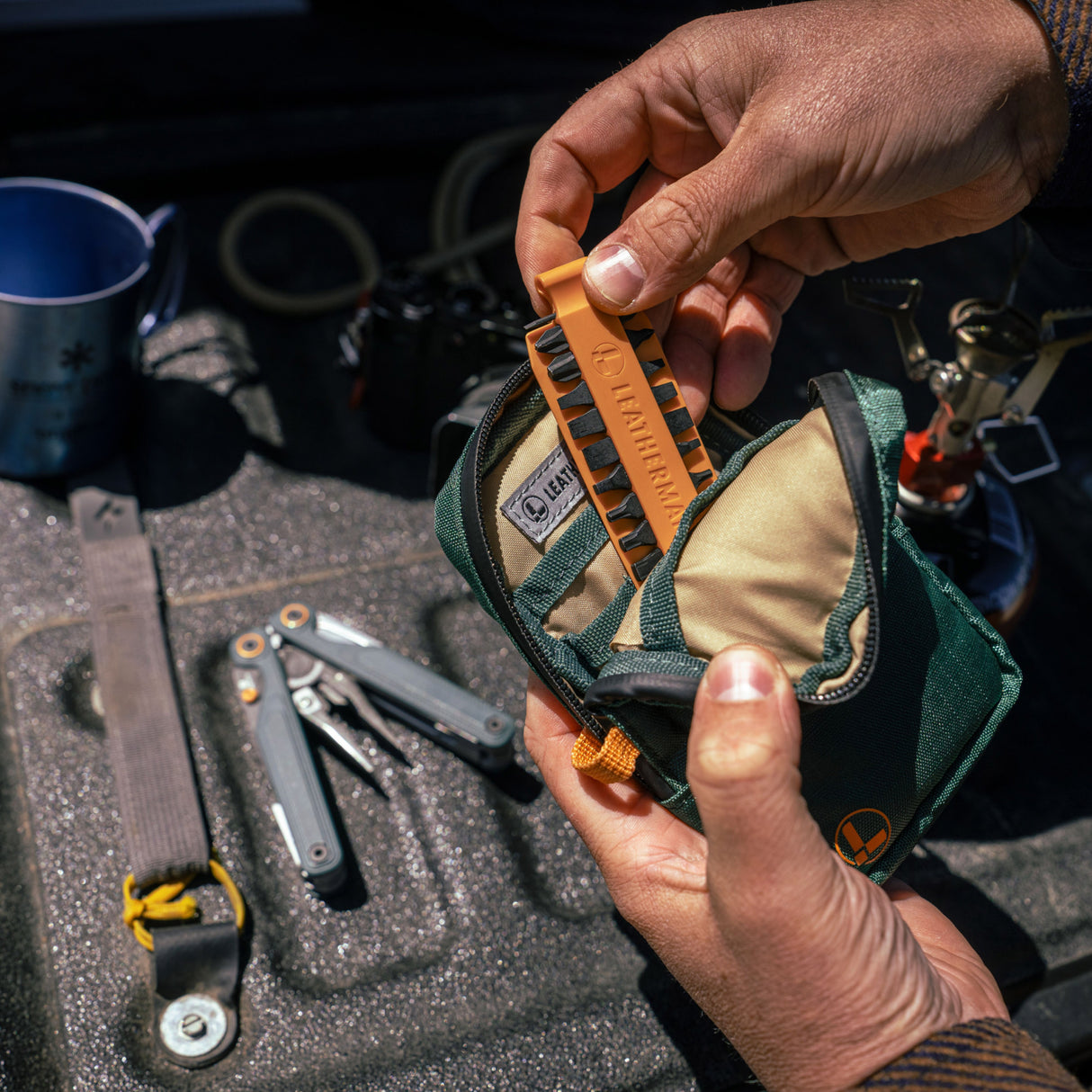 Translation missing: en.A person placing Orange Leatherman Bit Kit  into Tool Pouch