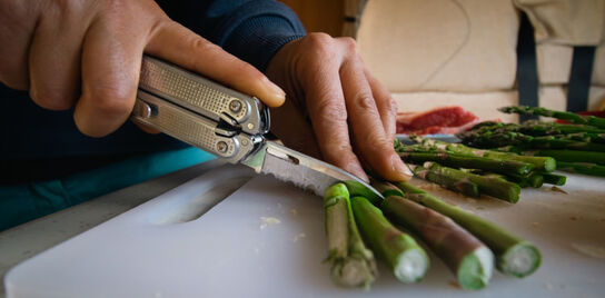 P2 cutting asparagus and a skeletool next to the asparagus cooked