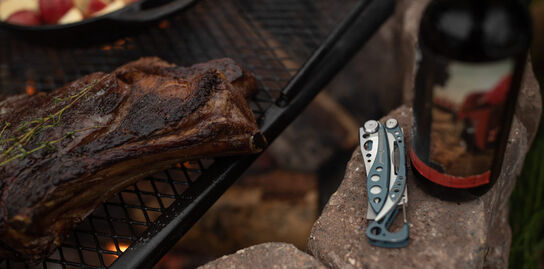 Leatherman Skeletool next to a camp grill