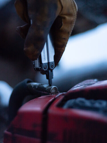 Mechanic fixing car with Leatherman tool
