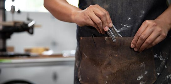 Man putting leatherman tool in apron pocket