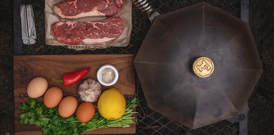 Cast iron skillet with steak and eggs ingredients 