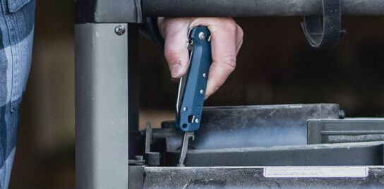Using the Philips screwdriver tool on a navy blue Leatherman FREE<sup>™</sup> K2.