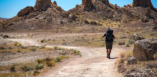 Hiker walking down a trail in the desert