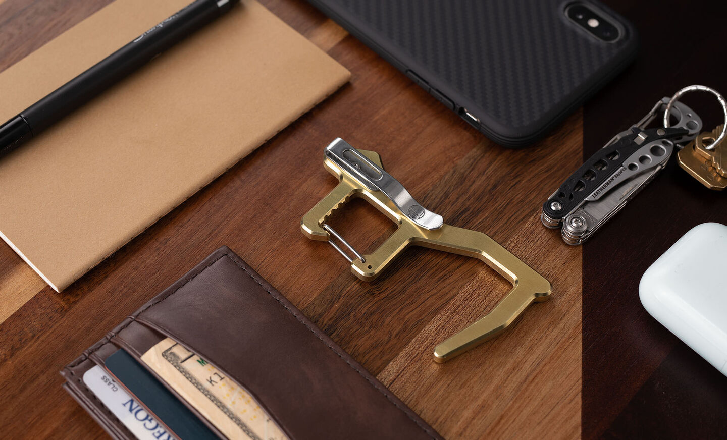 Clean Contact Carabiner on a desk next to a phone and wallet