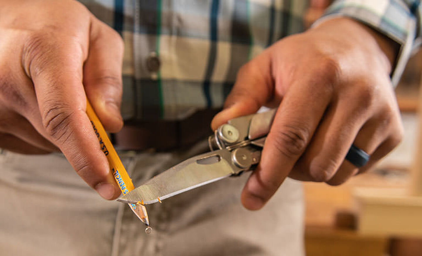 Man using knife blade on Leatherman Curl to sharpen yellow pencil 