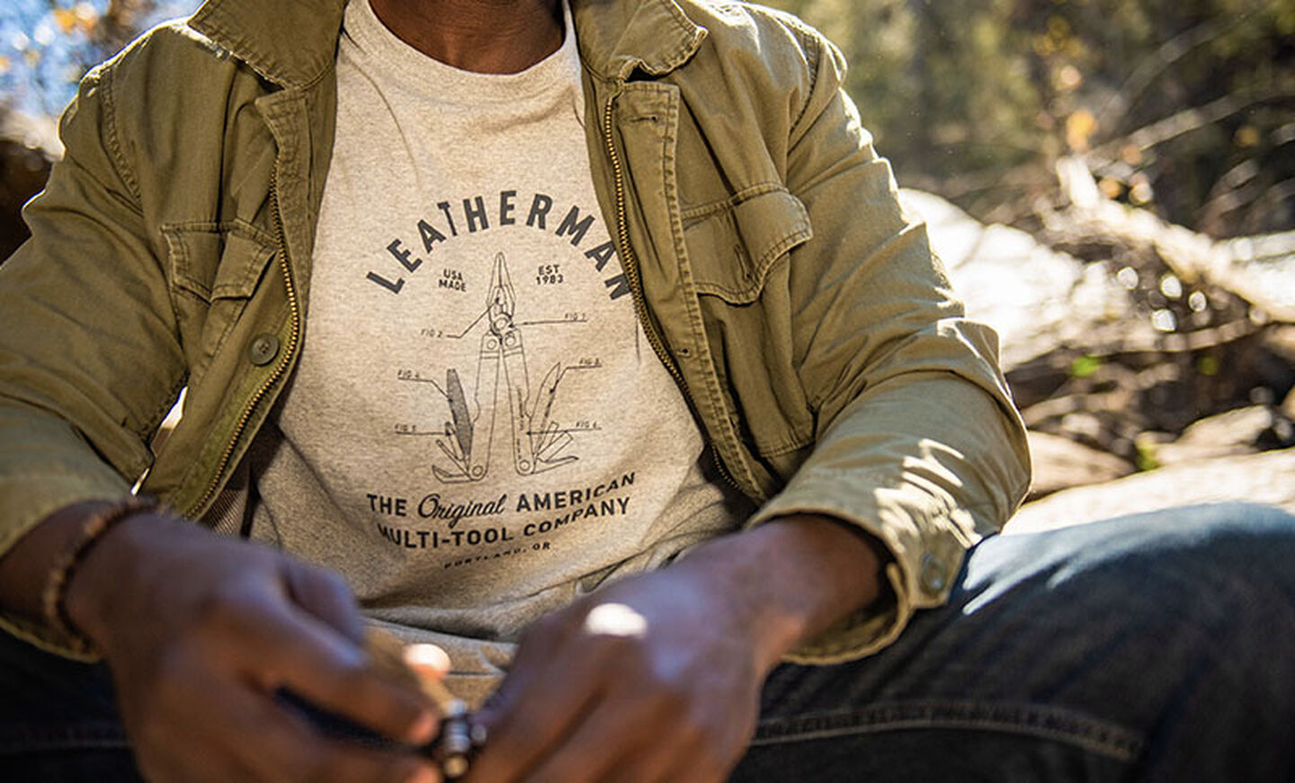 Outdoorsman wears gray Leatherman PST Heritage T-Shirt while camping.