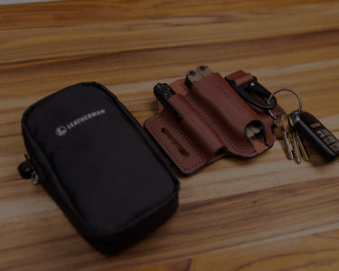 leatherman tool pouch and ainsworth edc sheath containing flashlight, multi-tool and keys on table