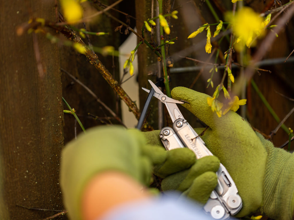 leatherman wave cutting a wired fence in a garden