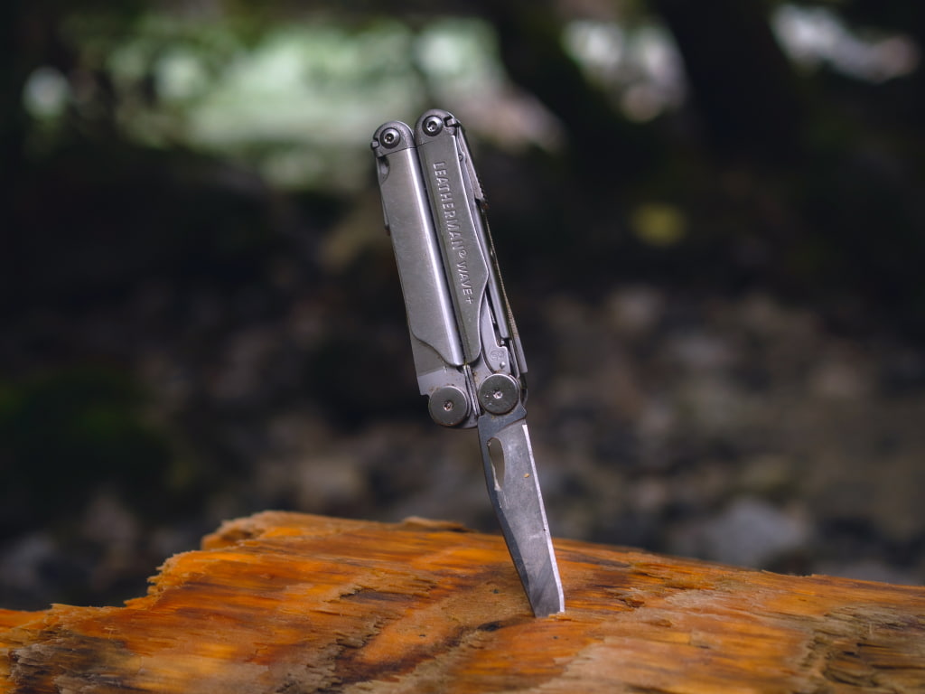 leatherman wave with blade in wood outdoors