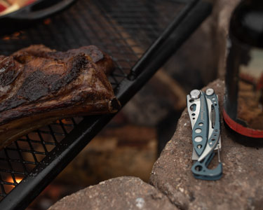 Leatherman Skeletool next to an outdoor grill