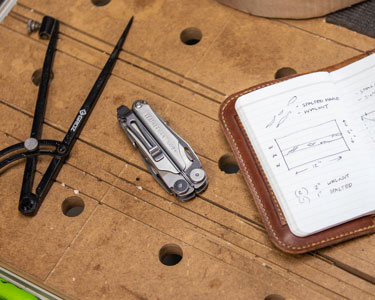 A Leatherman on a workbench with a notebook