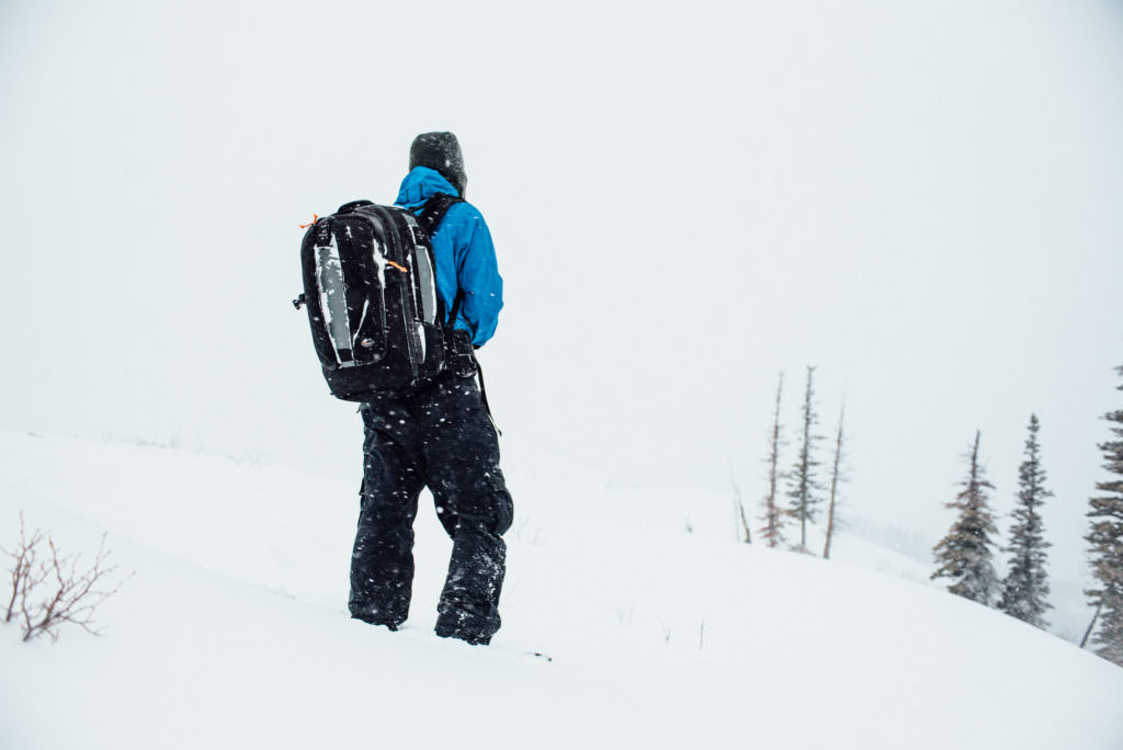 Photographer Isaac Miller out in the snow with his camera equipment. A cold, snowy day capturing scenic images in the Wasatch Mountains of Utah.