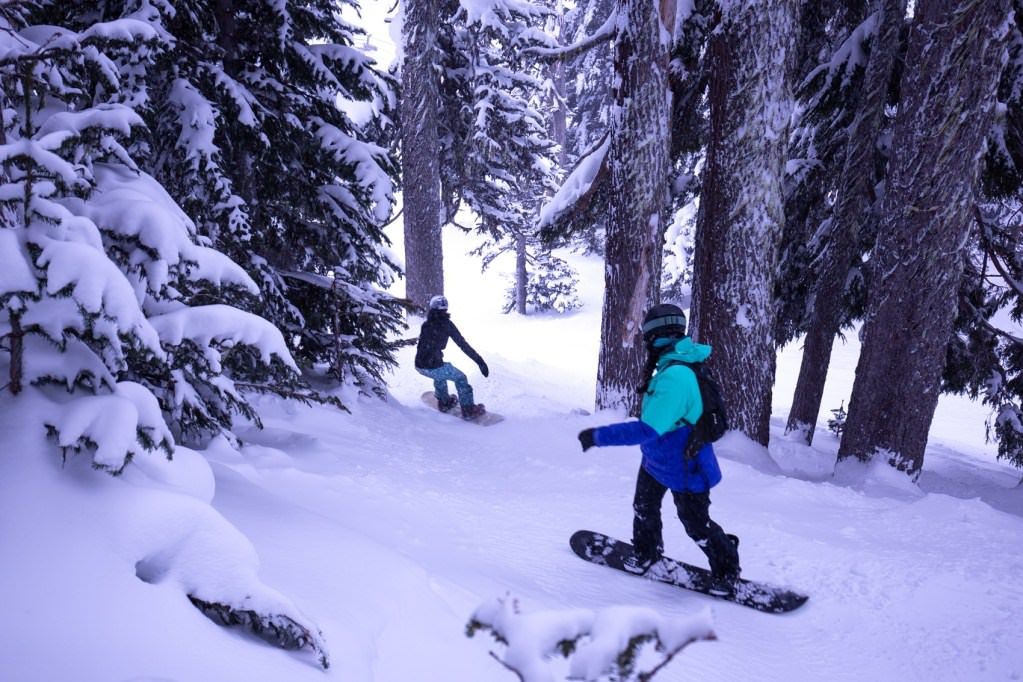 Two snowboarders navigate their way through the trees up at Mt. Hood Meadows.