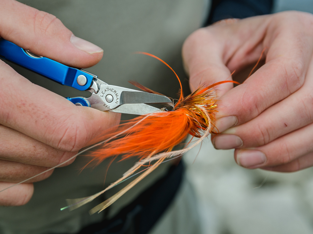 Leatherman squirt being used to trim line on a lure