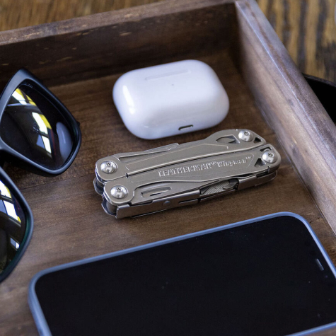  Leatherman wingman with a phone, sunglasses and headphones