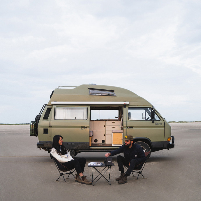 Two people sitting outside a van